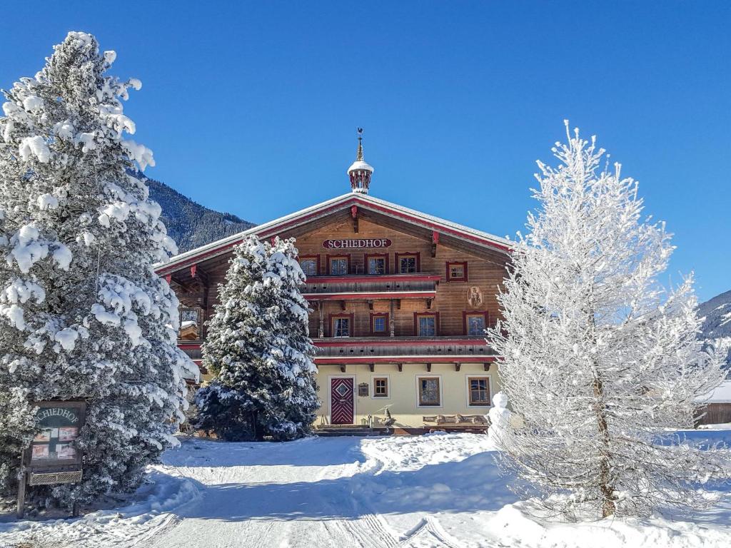 a large building with snow covered trees in front of it at Landhaus Schiedhof in Neukirchen am Großvenediger