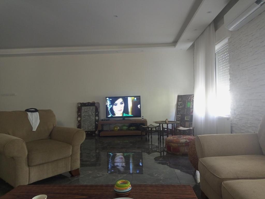 sala de estar con sofá y TV en جبل عمان الدوار الخامس, en Amán