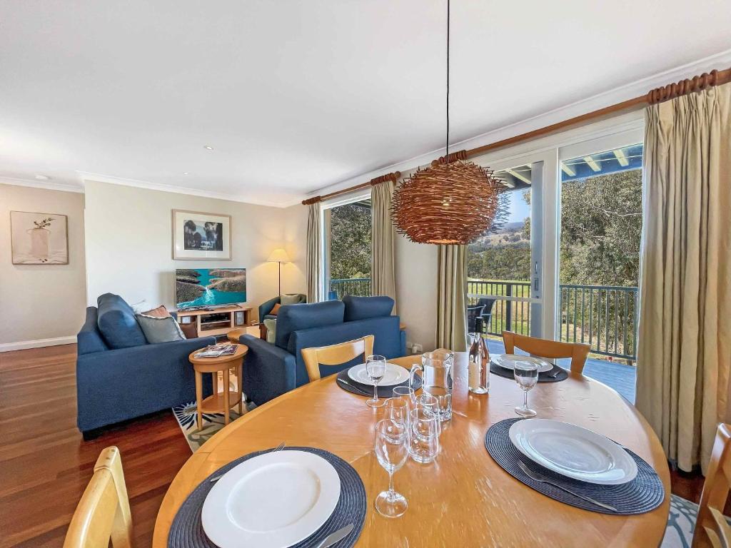 a dining room and living room with a table and chairs at Villa Grenache in Pokolbin