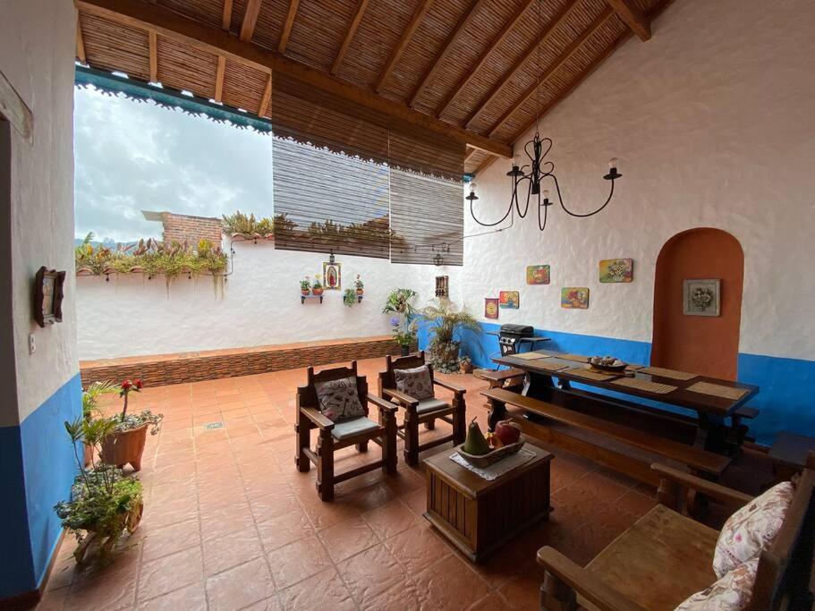 een woonkamer met meubilair en een groot raam bij Mi casita “Chinco” estrellas in Zapatoca
