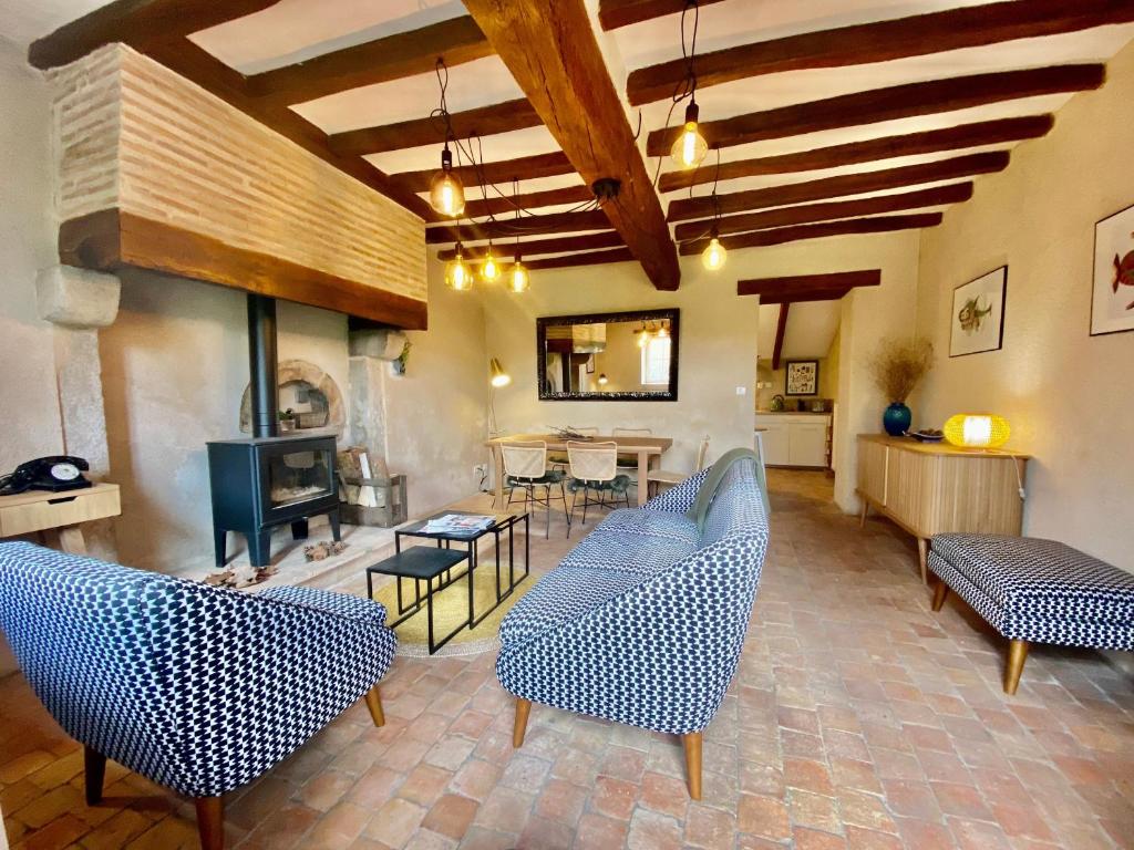 un salon avec des chaises bleues et une cheminée dans l'établissement Gîte charmant proche du Mans et de la Flèche, tout confort, jardin clos, garage, animaux bienvenus - FR-1-410-313, à Courcelles-la-Forêt