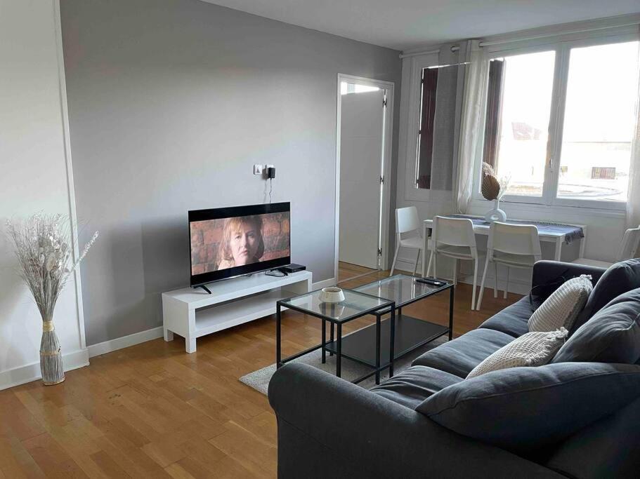 a living room with a couch and a flat screen tv at Super appartement à vitry-sur-seine in Vitry-sur-Seine