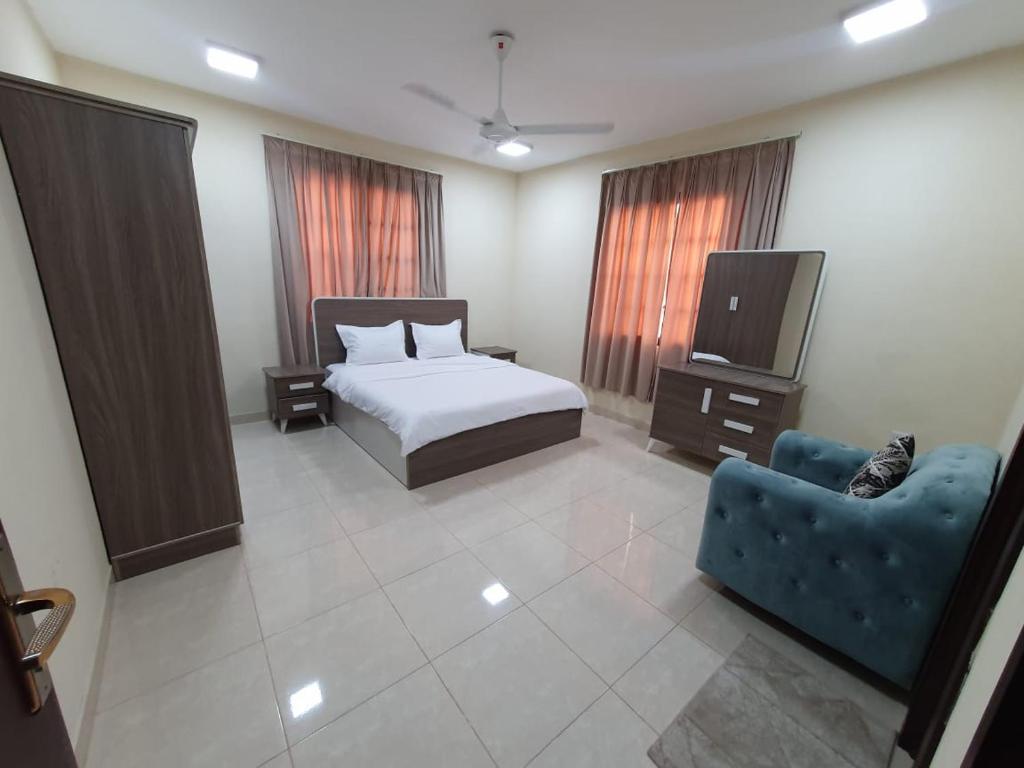 a bedroom with a bed and a tv and a couch at Terhal salalah 1 in Salalah