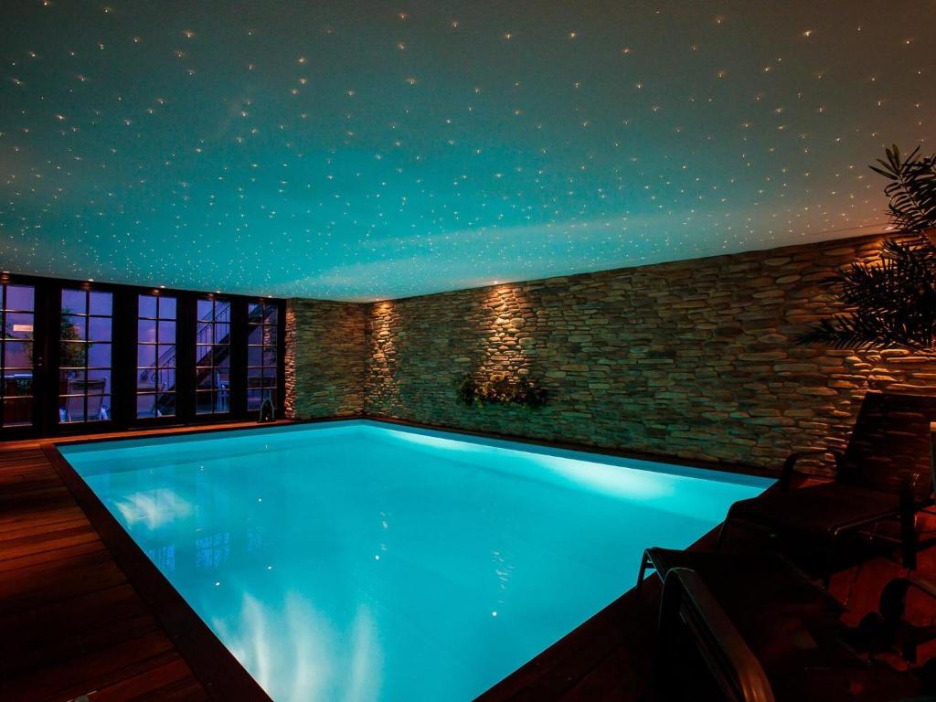 een zwembad in een huis 's nachts bij Unique holiday home with starry sky pool in Culemborg