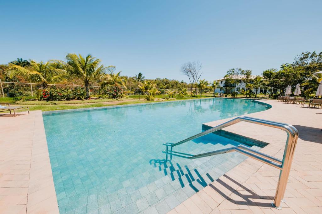 ein großer Pool mit blauem Wasser in einem Resort in der Unterkunft Eita Bahia in Praia do Forte