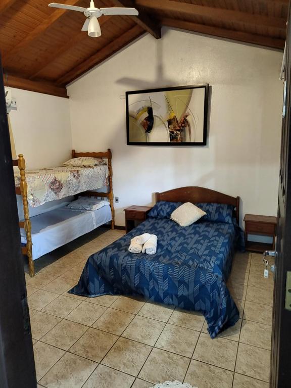 1 dormitorio con 1 cama y 2 literas en Recanto do Pajé, en Praia do Rosa