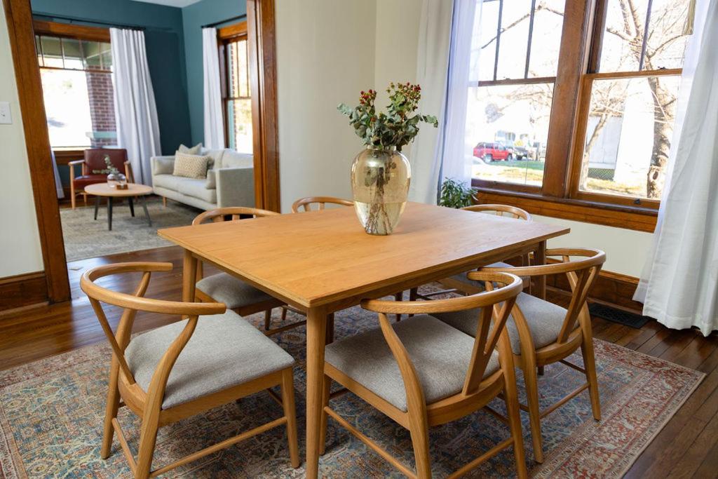 a wooden table with chairs and a vase with flowers on it at 4 Bedroom Suite At The Historic Winona House in Roanoke