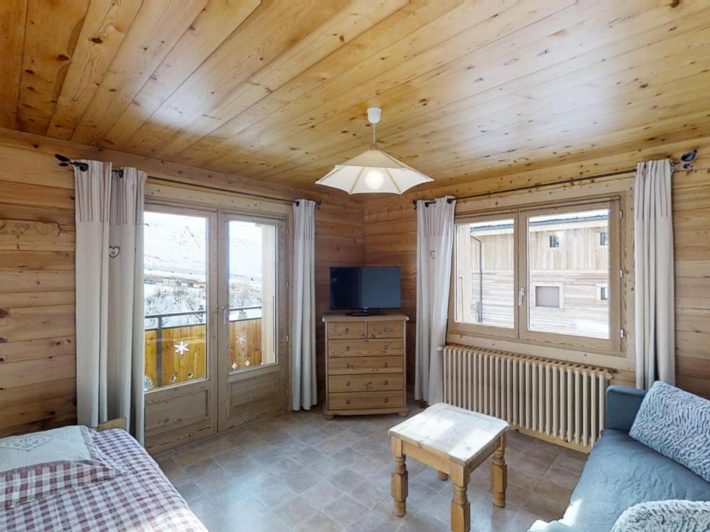 uma sala de estar com um sofá e uma televisão numa cabana de madeira em Appartement Le Grand-Bornand, 3 pièces, 6 personnes - FR-1-467-47 em Le Grand-Bornand