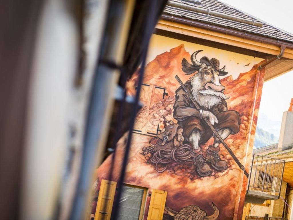 une peinture murale sur le côté d'un bâtiment avec une peinture d'une chèvre dans l'établissement Appartement 6 pers. au pied des pistes, parking - FR-1-467-94, au Grand-Bornand