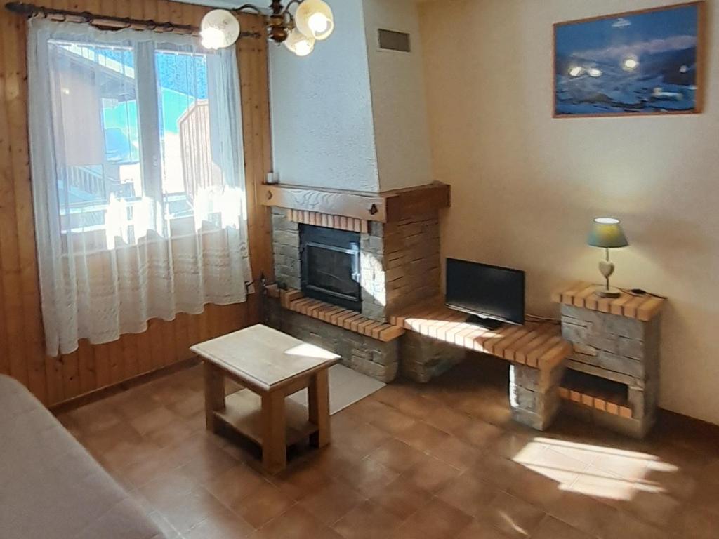 un salon avec une cheminée et un canapé dans l'établissement Appartement 52m² pour 5 pers proche pistes, accès facile, animaux admis – Le Grand-Bornand Village - FR-1-467-77, au Grand-Bornand