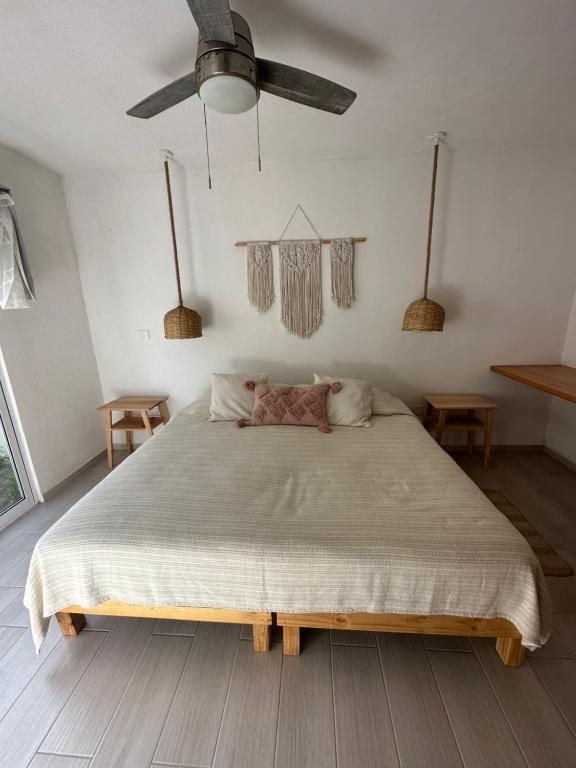 una camera con un grande letto e un ventilatore a soffitto di Boca de agua Villas a Nautla