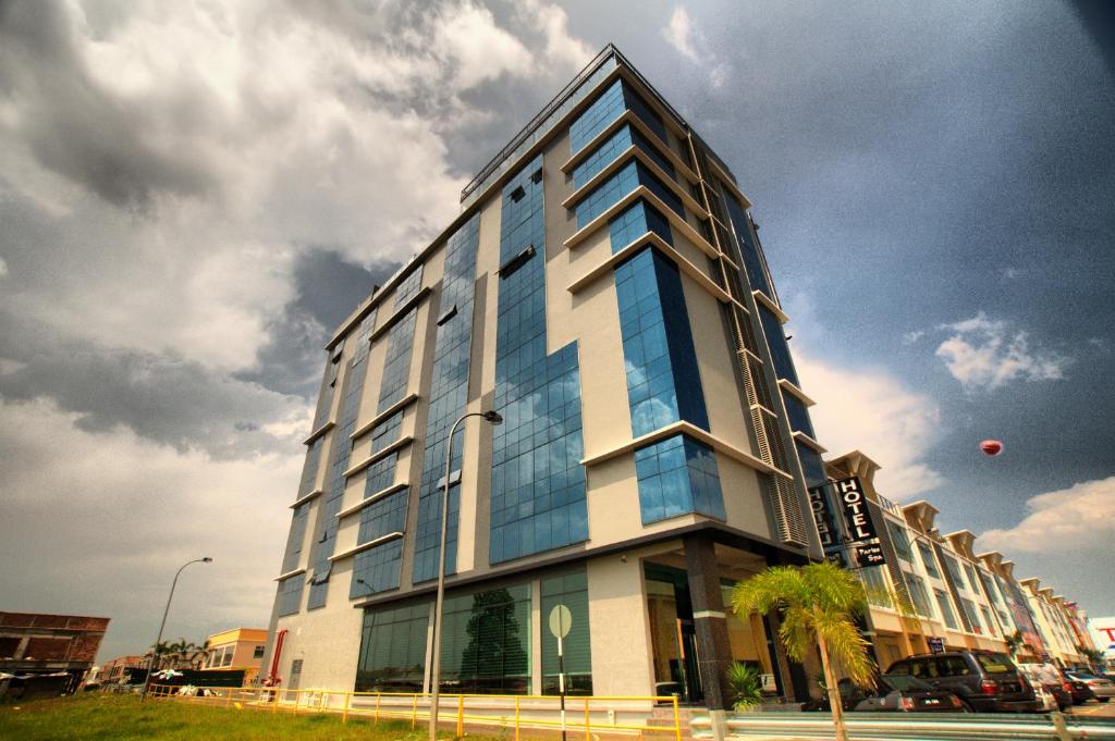 a tall building with glass windows on a street at Pariss Hotel in Johor Bahru