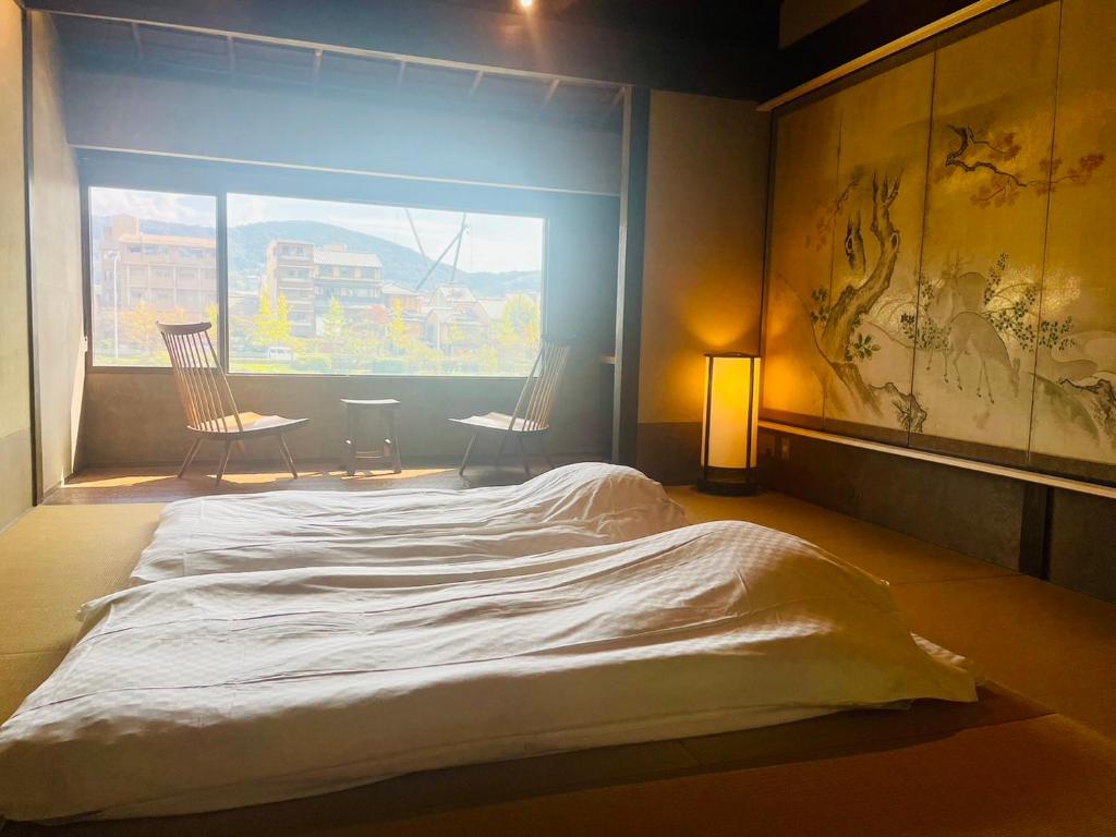 a large bed in a room with a window at 京都　水凪庵　Kyoto Mizunagian in Giommachi
