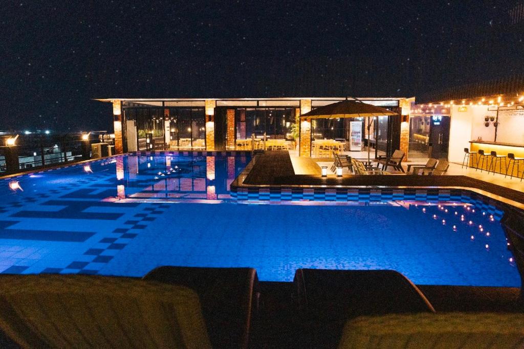 ein Schwimmbad in der Nacht mit einem Gebäude in der Unterkunft THE KOA Hotel & Spa in Angeles