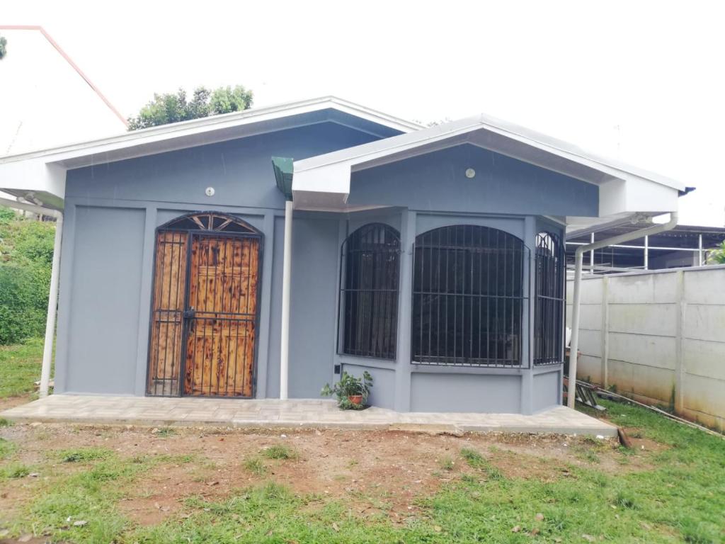 una pequeña casa con una gran puerta de madera en Casa Tangara, en San Isidro