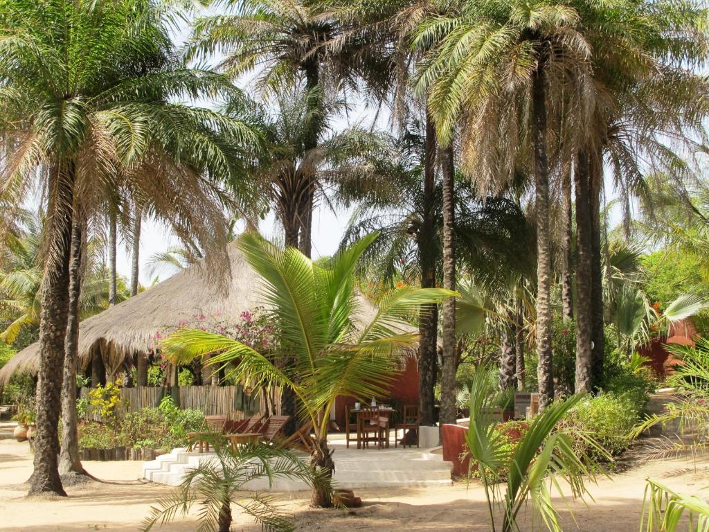 a resort with palm trees and a hut at Esperanto Lodge in Kafountine
