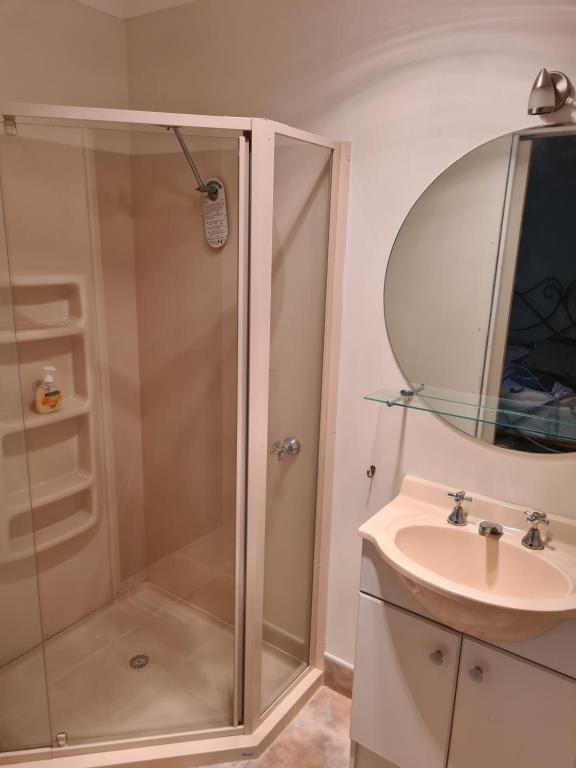 een badkamer met een douche en een wastafel bij Bird Songs Getaway Accommodation in Cabbage Tree Creek