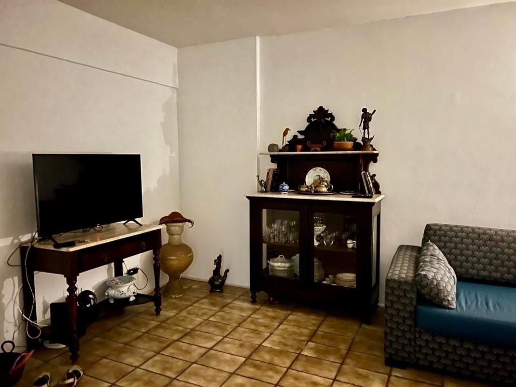 ein Wohnzimmer mit einem TV und einem Sofa in der Unterkunft Suite aconchegante na Torre in Recife