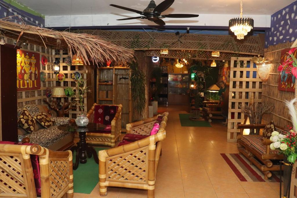 - un salon avec des chaises et un ventilateur de plafond dans l'établissement Green Leaf Guest House ColIege Road Sreemongal, à Sreemangal