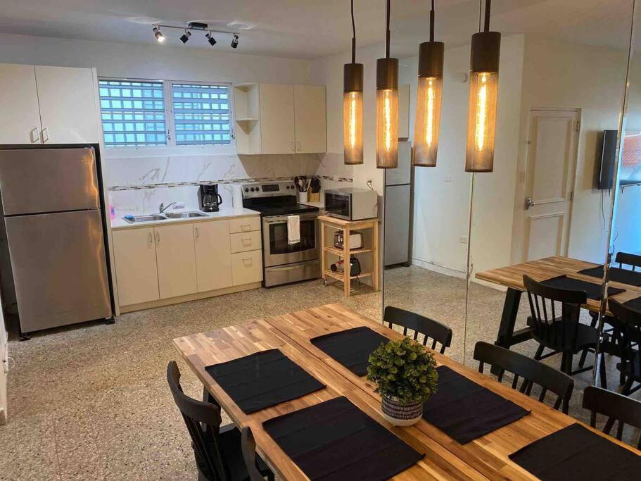 a kitchen and dining room with a wooden table and chairs at 3 bd by airport El yunque Walk to the beach in San Juan