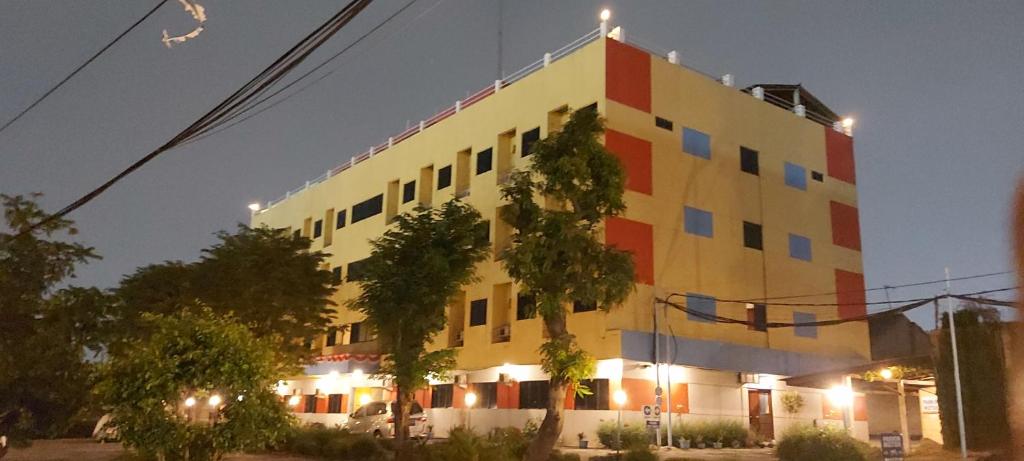 a yellow and red building with lights on it at Sentosa Hotel & Restaurant - tersertifikasi CHSE dari Kementerian Pariwisata dan Ekonomi Kreatif in Bekasi