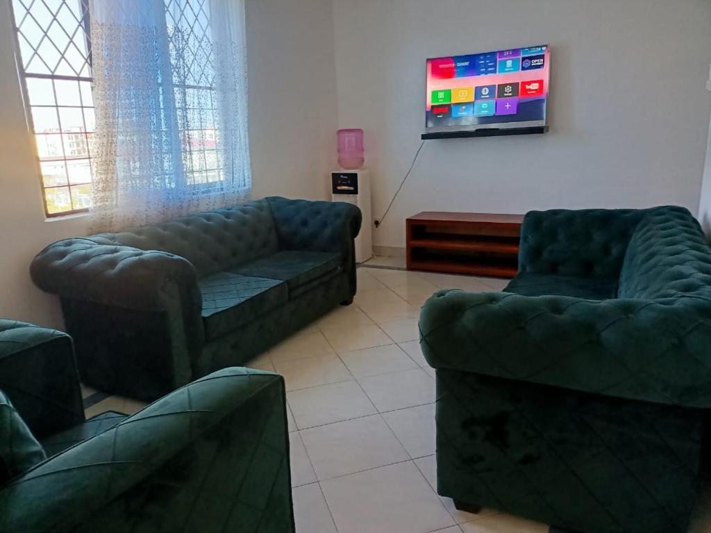 salon z 2 kanapami i telewizorem w obiekcie Mombasa , Kenya 2 bedroom Master Ensuite w mieście Mombasa