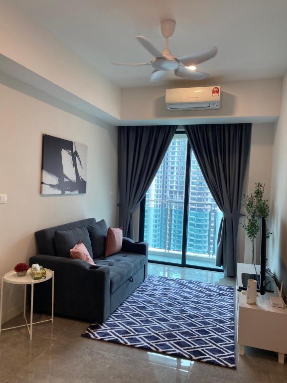 Ooak Residence in Mont Kiara, Kuala Lumpur في كوالالمبور: غرفة معيشة مع أريكة ومروحة سقف