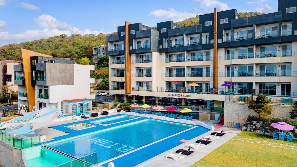 un hotel con piscina frente a un edificio en Ganghwa Elijah Resort en Incheon