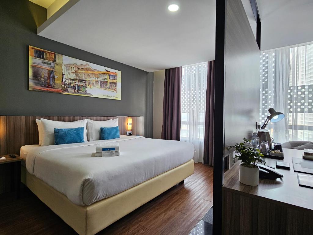 een hotelkamer met een groot bed en een bureau bij Days Hotel & Suites by Wyndham Fraser Business Park KL in Kuala Lumpur