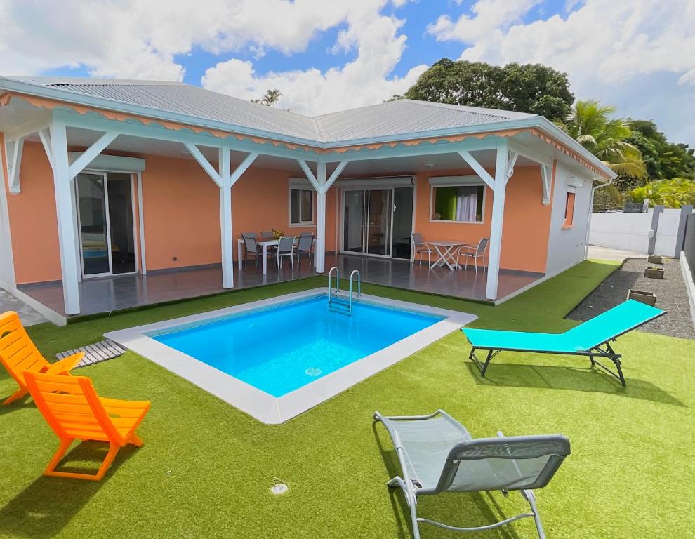 une maison avec une piscine dans la cour dans l'établissement Évasion tropicale Villa de rêve avec piscine à Petit Bourg, à Petit-Bourg