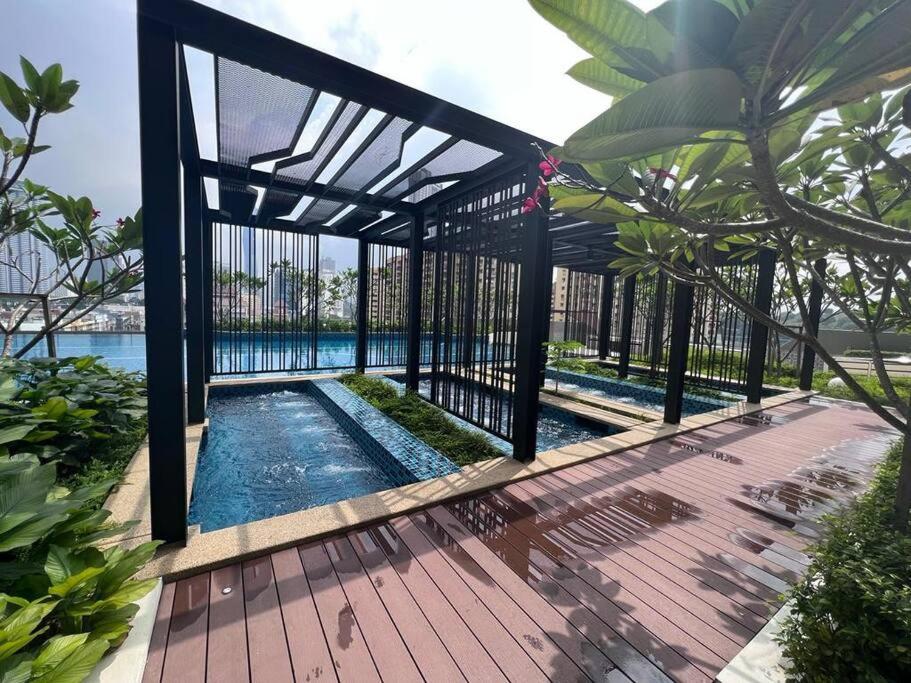 a swimming pool with a fence and a wooden deck at Sentral Suites Kuala lumpur By Leyla in Kuala Lumpur