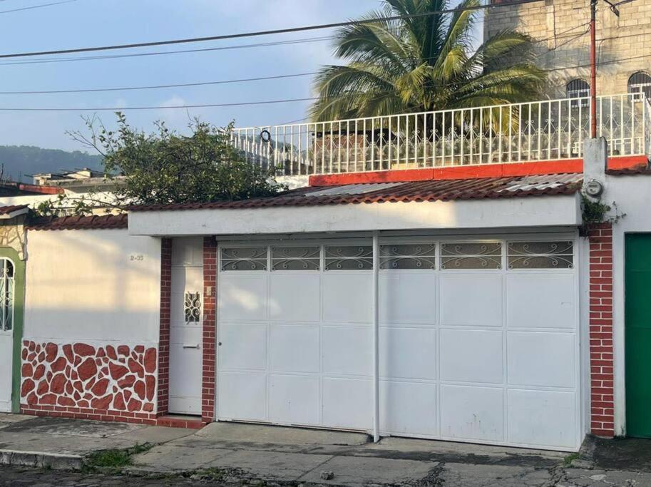 a pair of white garage doors on a building at comfortable and spacious house with garage in Amatitlán