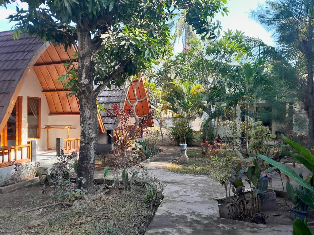 uma casa com um monte de árvores na frente dela em Florine's Garden em Gili Air