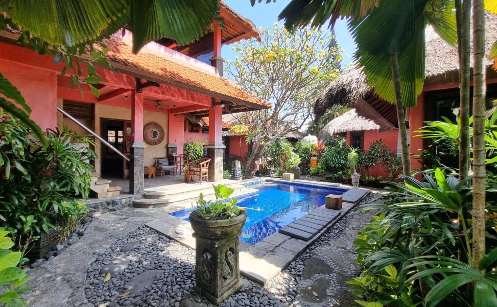 a house with a swimming pool in the yard at Flash Back Bungalow in Sanur