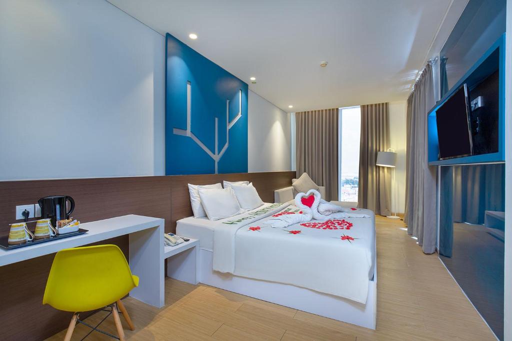 a bedroom with a bed and a desk and a chair at 1O1 URBAN Jakarta Pemuda in Jakarta