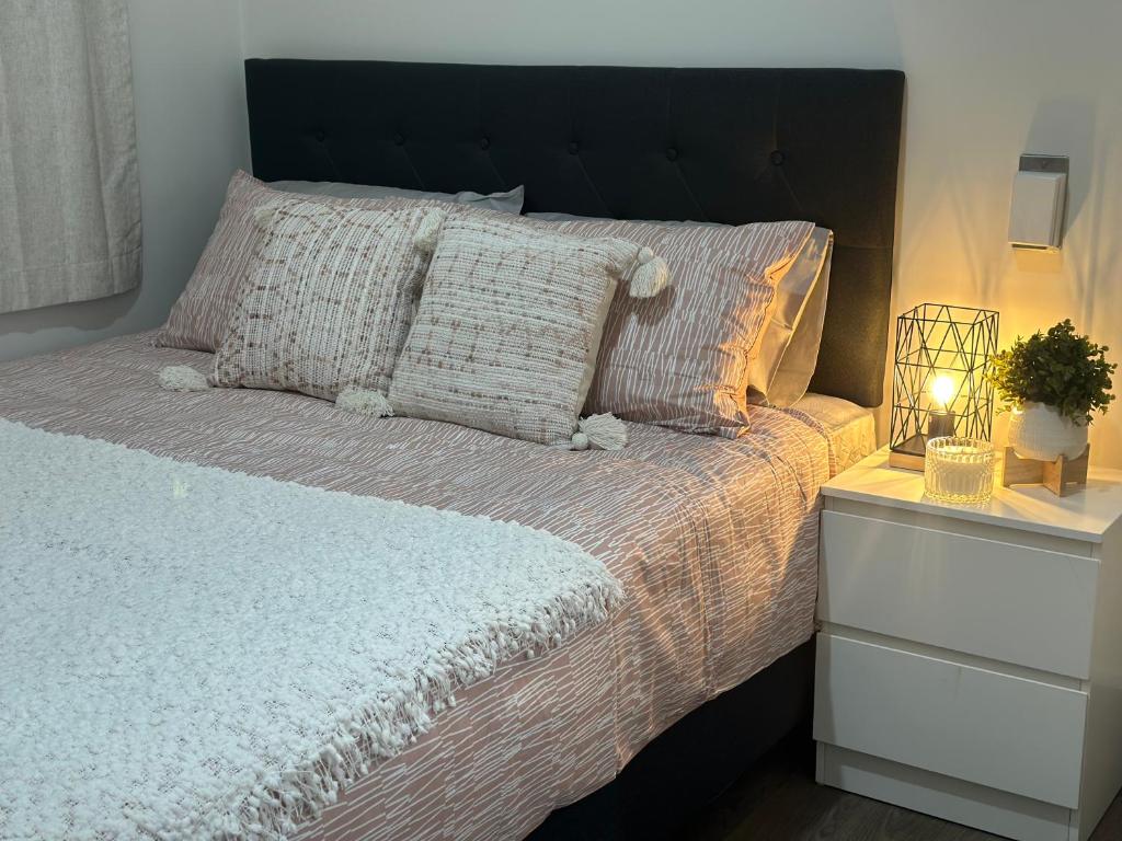 a bedroom with a large bed with a black headboard at Eden Lodge in Auckland