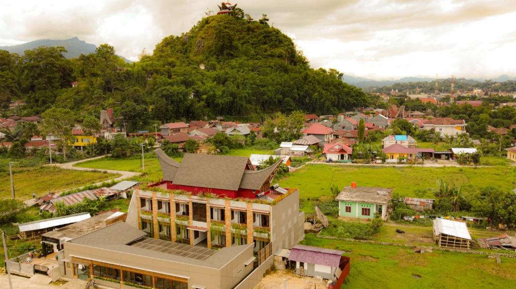a small village with a building and a hill at Santai Toraja in Rantepao