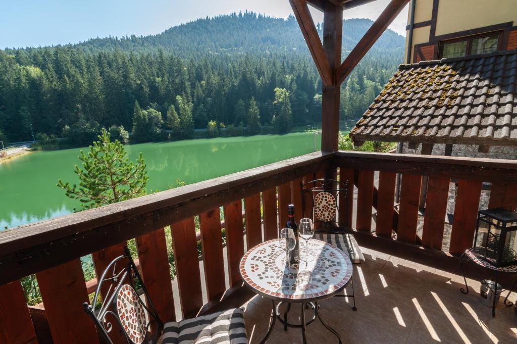 a balcony with a table and chairs and a view of a river at Vila Viktória - Apartmán Viktória 2 in Ružomberok
