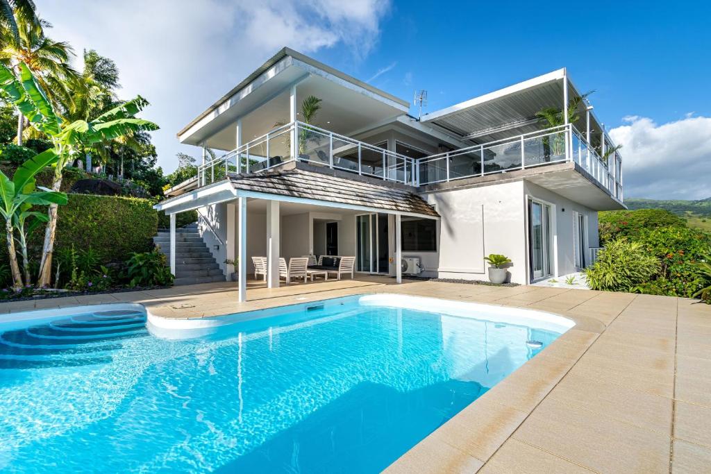 une maison avec une piscine en face d'une maison dans l'établissement Toahotu estate one of a kind villa in Tahiti Iti pool and view - 15 pers, à Vairao