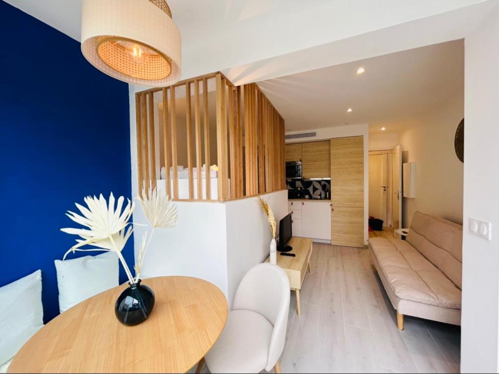 a living room with a table and a couch at Riviera 1 ou Riviera 2 ou réservez les 2 Front de Mer Cagnes sur Mer Promenade de la plage in Cagnes-sur-Mer