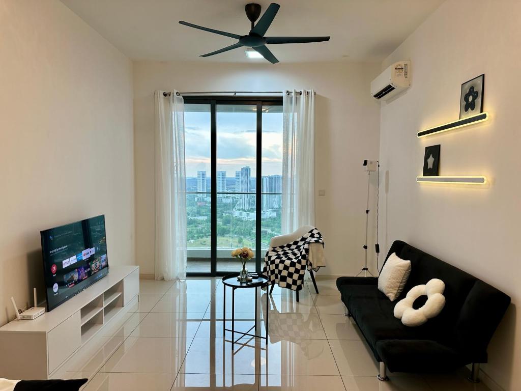 een woonkamer met een zwarte bank en een plafondventilator bij Elysia Park Residence Medini Homestay Legoland Gleneagles Johor in Nusajaya