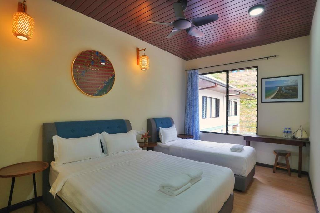 - une chambre avec 2 lits et une fenêtre dans l'établissement Tranquera House, à Ranau