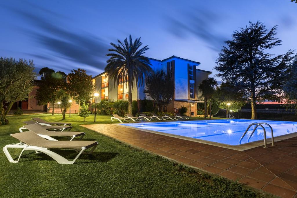 - une piscine avec des chaises longues à côté d'un bâtiment dans l'établissement Hotel Sausa, à Vilafreser