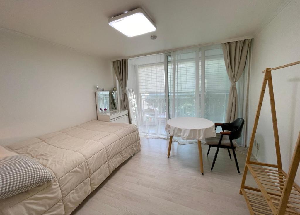 1 dormitorio con cama, escritorio y mesa en Haeng Un - For Foreigner & Female Only en Suwon