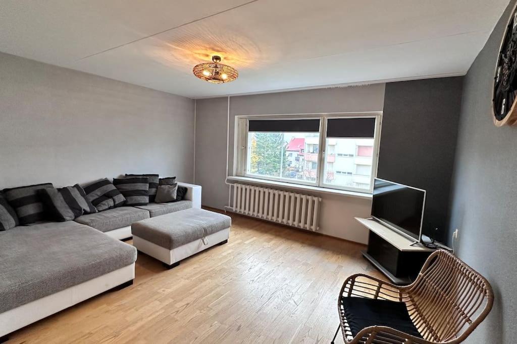 a living room with a couch and a tv at Only 5 min. From Tallinn Airport in Petrikyula