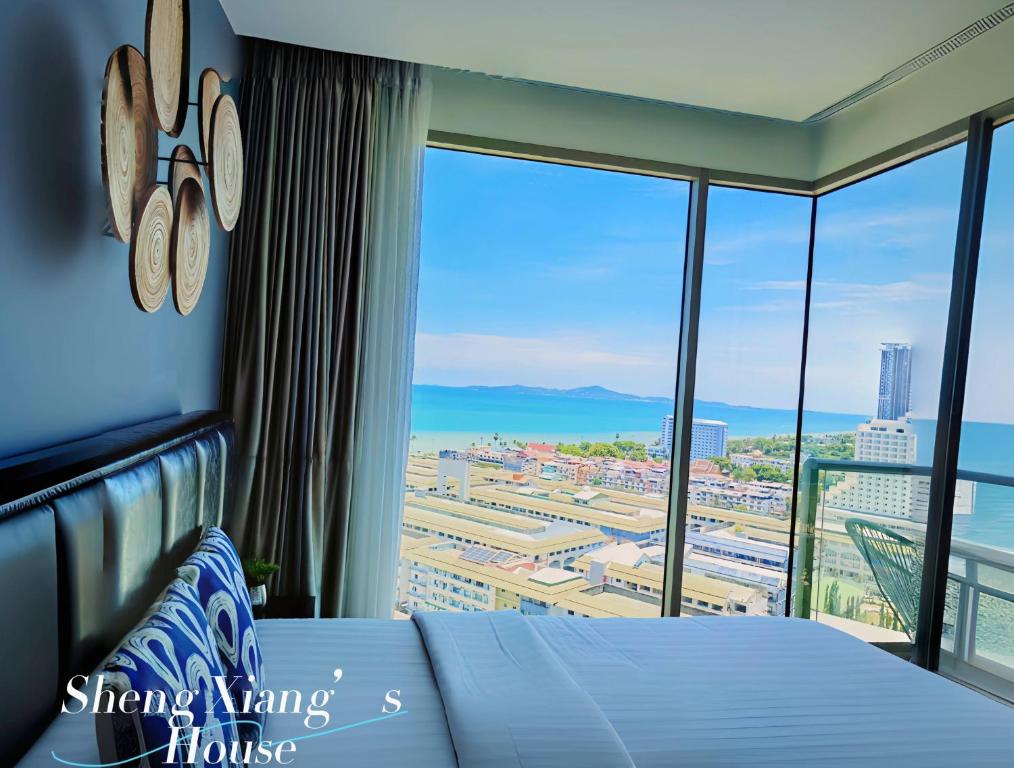 a bedroom with a bed and a large window at 芭提雅高层海景奢华公寓The Riviera Jomtien生香家直达海滩23 in Jomtien Beach