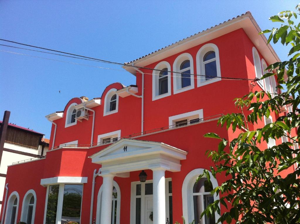 a red building with white columns and windows at Villa Favorita in Eforie Sud