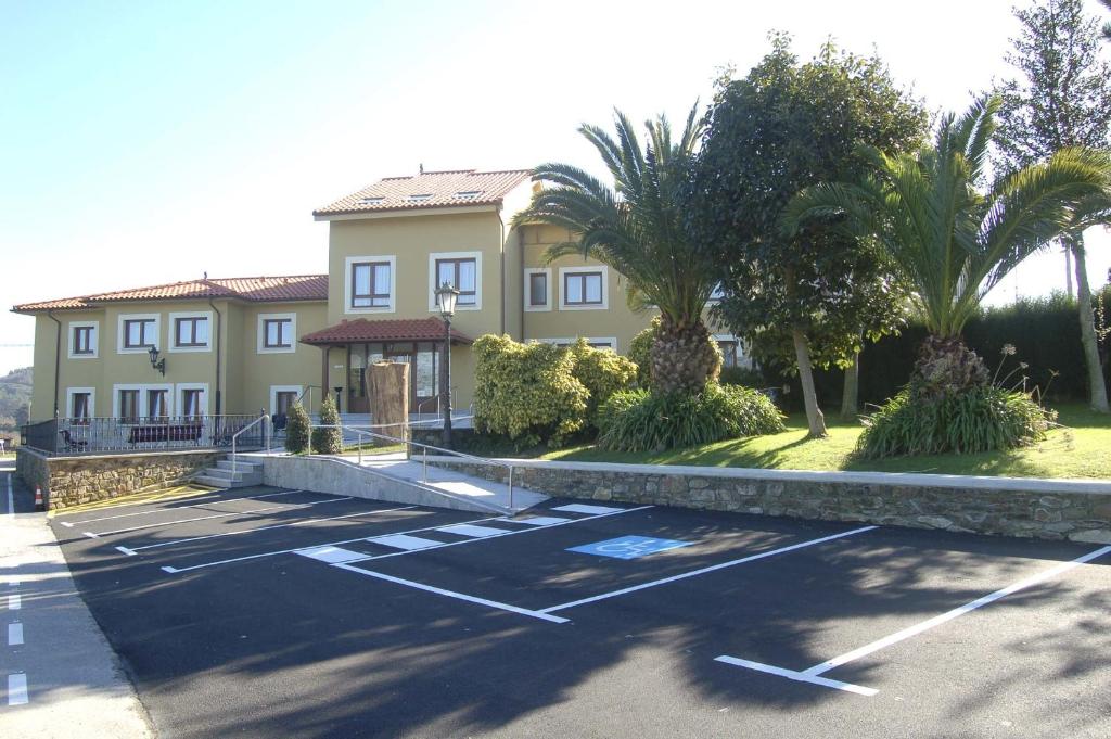 a house with a parking lot in front of it at Hotel Lupa in San Juan de Piñera