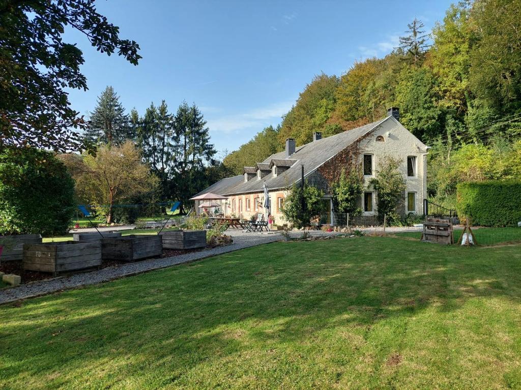 uma casa com um jardim de relva em frente em Au doux Chardon em Durbuy