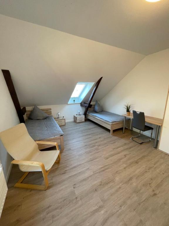 een zolderkamer met een bed en een bureau bij Gästehaus Landleben am Deich in Balje
